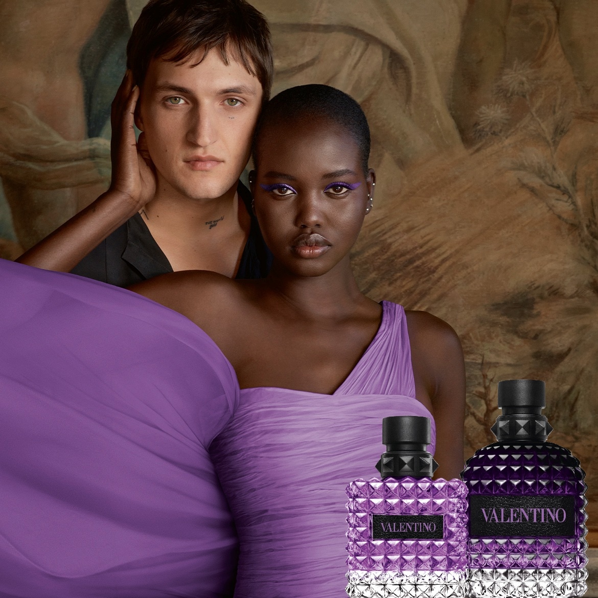 Découvrez Valentino Born in Roma Intense, un parfum captivant présenté avec élégance par un couple devant une toile de fond artistique.