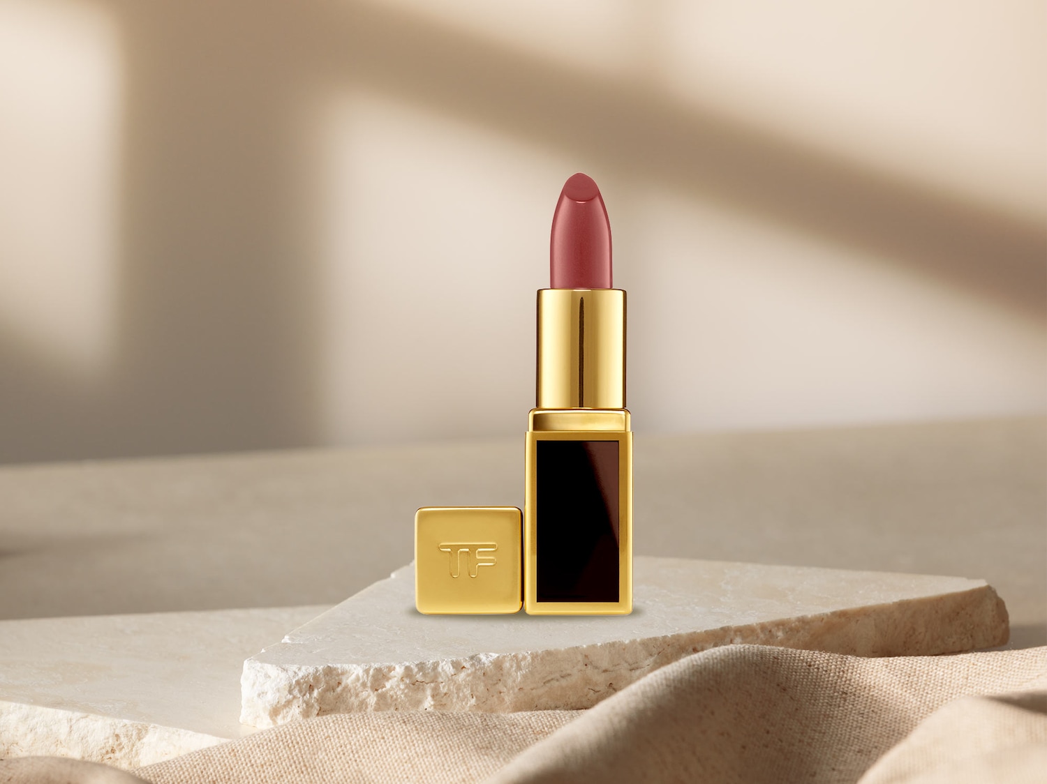 Dä Tom Ford Lippenstift präsentiert sich i sim elegante goldige Gehäuse, bereit zum d Lippe mit Farbe z verwöhne.