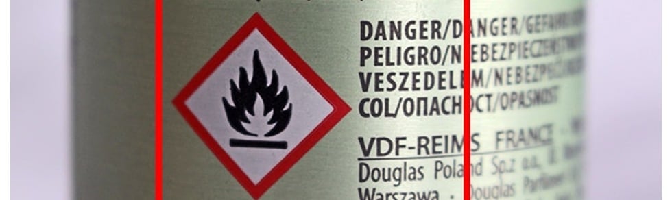 Auf der Dose ist ein Gefahrenzeichen abgebildet, das ein rotes Quadrat mit einer schwarzen Flamme zeigt, daneben steht in mehreren Sprachen "Danger".